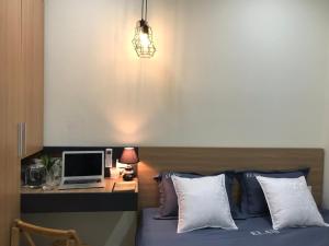 a bedroom with a bed and a desk with a laptop at SAOLA Apartment FAMILY in Hai Phong