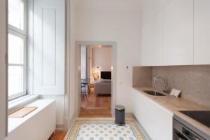 een keuken met een wastafel en een keukenkleed bij FLH Bacalhoeiros Spacious Apartment in Lissabon