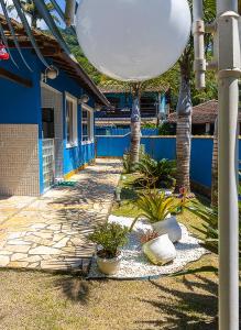 ein blaues Gebäude mit Bäumen und Pflanzen im Hof in der Unterkunft Casa azul Ilha Grande in Abraão