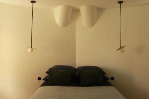 1 dormitorio con 1 cama con 2 luces encima en Studio très cosy - indépendant dans une péniche - Paris 16 en Puteaux