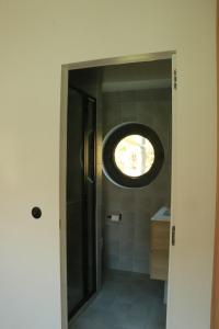 La salle de bains est pourvue d'une fenêtre ronde. dans l'établissement Studio très cosy - indépendant dans une péniche - Paris 16, à Puteaux