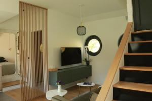 a living room with a television and a staircase at Studio très cosy - indépendant dans une péniche - Paris 16 in Puteaux
