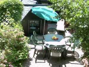 a patio with a table and chairs and an umbrella at Ferienhaus Glöckner in Seiffen