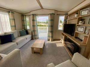 a living room with a couch and a tv at Bellevue in South Cerney