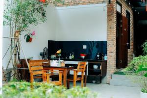a wooden table and chairs on a patio at Chi’s homestay in Thôn Kim Long (1)