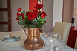 un vase rempli de roses rouges assis sur une table dans l'établissement Apartamento BIO Exclusivo con mirador en Bilbao y aparcamiento público gratuito, à Bilbao