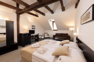 a bedroom with a large bed and a living room at Bazilika alatt Panzió in Esztergom
