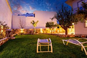 a lawn with two chairs in the yard at night at Bitsakis Family - Paleochora Luxury Villa in Palaiochora