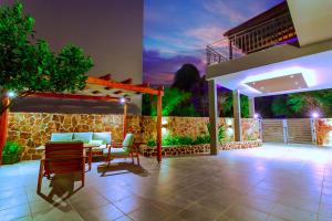 a patio with a table and chairs and a building at Bitsakis Family - Paleochora Luxury Villa in Palaiochóra
