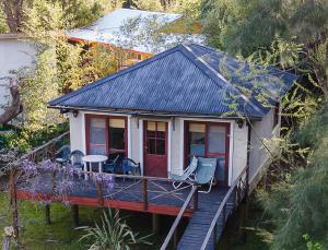 Casa pequeña con terraza con mesa y sillas en Victoria Cabañas en Tigre