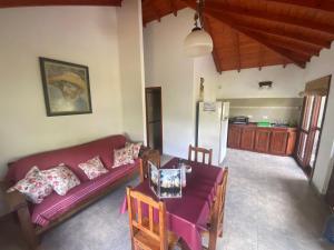 ein Wohnzimmer mit einem lila Sofa und einem Tisch in der Unterkunft Victoria Cabañas in Tigre