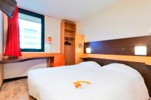 a hotel room with two beds and a window at Première Classe Paris-Ouest Gennevilliers in Gennevilliers