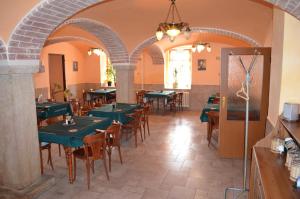 a restaurant with green tables and chairs in a room at Motorest Penzion na Bojišti in Chlumec