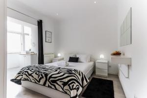 1 cama con estampado de cebra en un dormitorio blanco en Downtown Lisbon Palma Suites by Homing, en Lisboa
