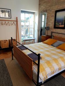 a bedroom with a large bed and a brick wall at Belvárosi Kertesház in Keszthely