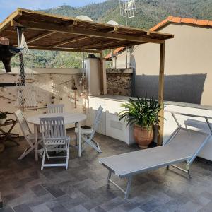 a patio with a table and chairs and a swing at Sea view Cornelia in Corniglia