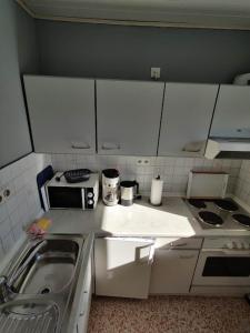 a small kitchen with white cabinets and a sink at Hus Kalli in Landkirchen