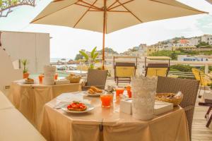 a table with plates of food and an umbrella at b&b da Laura in Ponza
