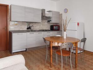 La cuisine est équipée d'une table, de chaises et d'un réfrigérateur. dans l'établissement sedicipassi, à Villaggio Azzurro
