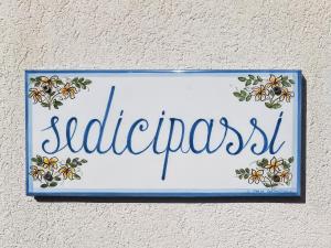 um sinal numa parede que em sedicipassi em Villaggio Azzurro
