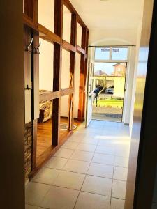 a hallway with an open door with a dog outside at Ferienhof - Ferienwohnung in Gadebusch