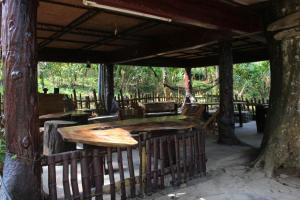 an outdoor dining area with a wooden table and trees at Jungle Jive Tree House in Munnar