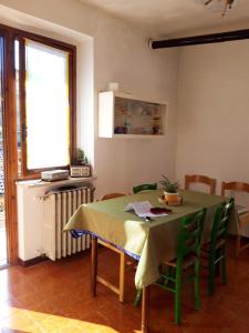 a dining room with a green table and chairs at One bedroom appartement with balcony and wifi at Monterosso Grana in Levata