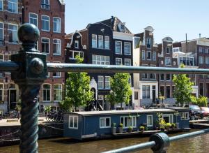 ein blaues Haus auf dem Wasser in einem Kanal mit Gebäuden in der Unterkunft Max Brown Hotel Canal District, part of Sircle Collection in Amsterdam