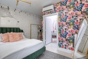 1 dormitorio con cama y pared de flores en The Oleander Hotel Room Number 3, en Galveston