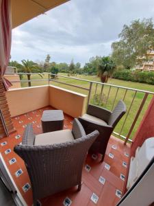 a balcony with chairs and tables and a view of a park at Minerva in Benalmádena