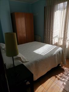 - une chambre avec un lit doté d'une lampe et d'une fenêtre dans l'établissement capricho 2 asturias COLOMBRES, à Ribadedeva