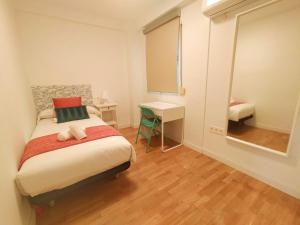 Dormitorio pequeño con cama y espejo en Plaza de España. Dreams en Sevilla