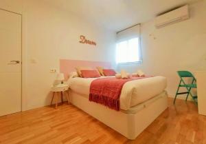 Un dormitorio con una cama con almohadas rosas y una ventana en Plaza de España. Dreams en Sevilla