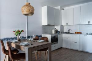 a kitchen with a wooden table with chairs and a dining room at Apartament Baltic Sea Gate Porta Mare 55m2 in Dziwnówek