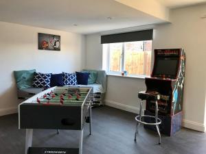 a living room with a foosball table and a tv at Stanford Villa in Stanford-le-Hope