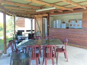 patio con mesa y sillas y cocina en Fare Arana Mooréa Guesthouse en Atiha