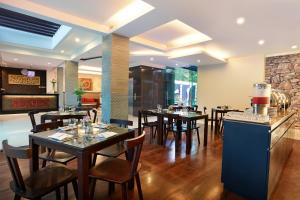 a restaurant with tables and chairs in a room at Argya Santi Suite and Villas in Seminyak