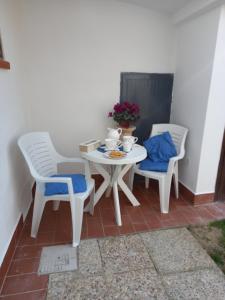 una mesa blanca y 2 sillas y una mesa y sillas blancas en Sole e mare, en San Felice Circeo