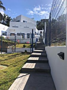 a stairway leading up to a white house at La Leona 1 in El Zonte