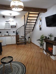 a living room with a fireplace and a staircase at Drozdówka nad Soliną - Domki BOHO in Solina