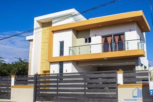 a white and yellow house with a black fence at 5 Star Villa minutes from Airport and Beaches in Sosúa