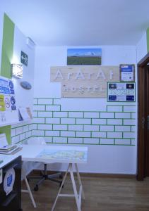 una habitación con una pared blanca con un cartel. en ArArAt Hostel, en Santiago de Compostela