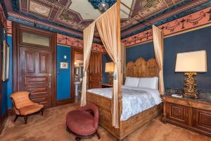 舊金山的住宿－Chateau Tivoli Bed and Breakfast，一间卧室配有一张天蓬床和一把椅子