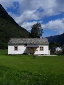 a white house in the middle of a field at An authentic experience in picturesque Eidfjord in Eidfjord