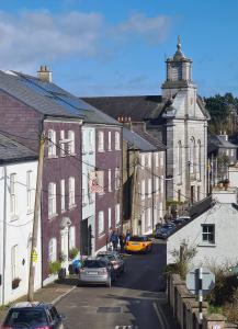 a town with cars parked on a street with buildings at Kinsale town cosy home 2 min walk to town center in Kinsale