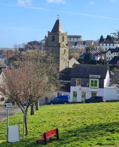 a park with a bench in a field with a building at Kinsale town cosy home 2 min walk to town center in Kinsale