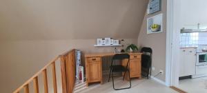 a kitchen with a wooden desk and two chairs at Central lägenhet med gratis parkering in Lindesberg