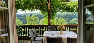 uma mesa e cadeiras numa varanda com vista em Restaurant & Hotel Zur Falkenhöhe em Falkenau