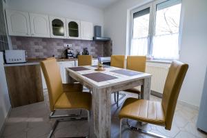cocina con mesa y sillas en una habitación en Thermal Next II Weninger Apartman Kiskunhalas, en Kiskunhalas