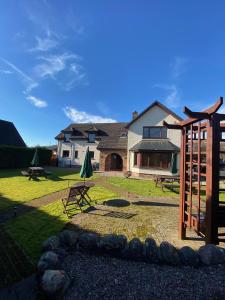 a backyard with a picnic table and a building at Highland Stays - Rushfield House Rooms in Fort William